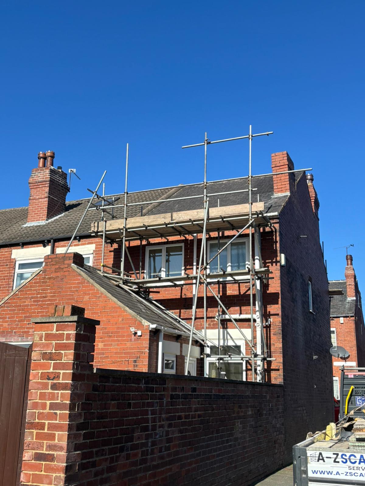 Scaffolding at roof level on a brick terraced house in Yorkshire